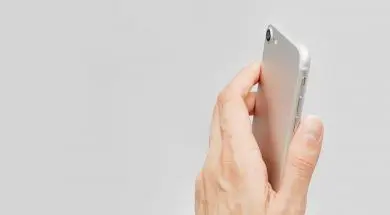Female hand holding cell phone isolated close up