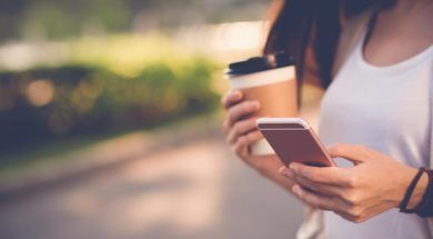 woman-holding-coffee-and-phone