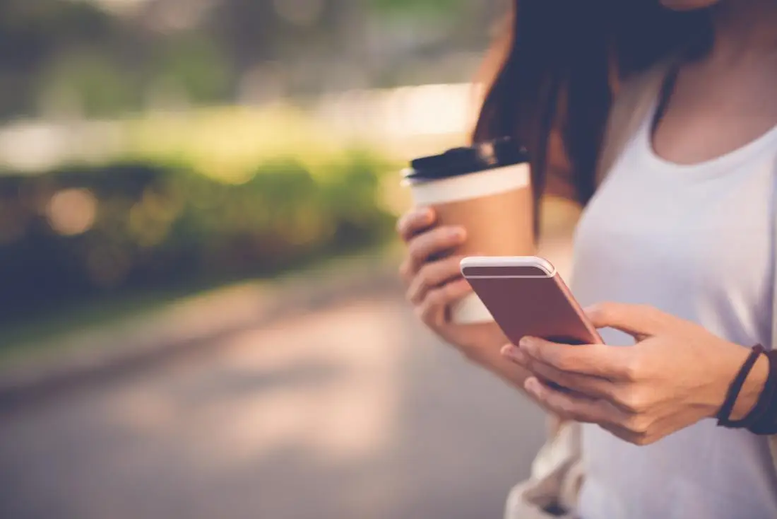 woman-holding-coffee-and-phone