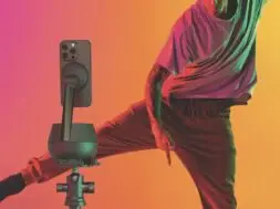 Portrait of young stylish man, break dancing dancer training in casual clothes isolated over gradient pink yellow background at dance hall in neon light.