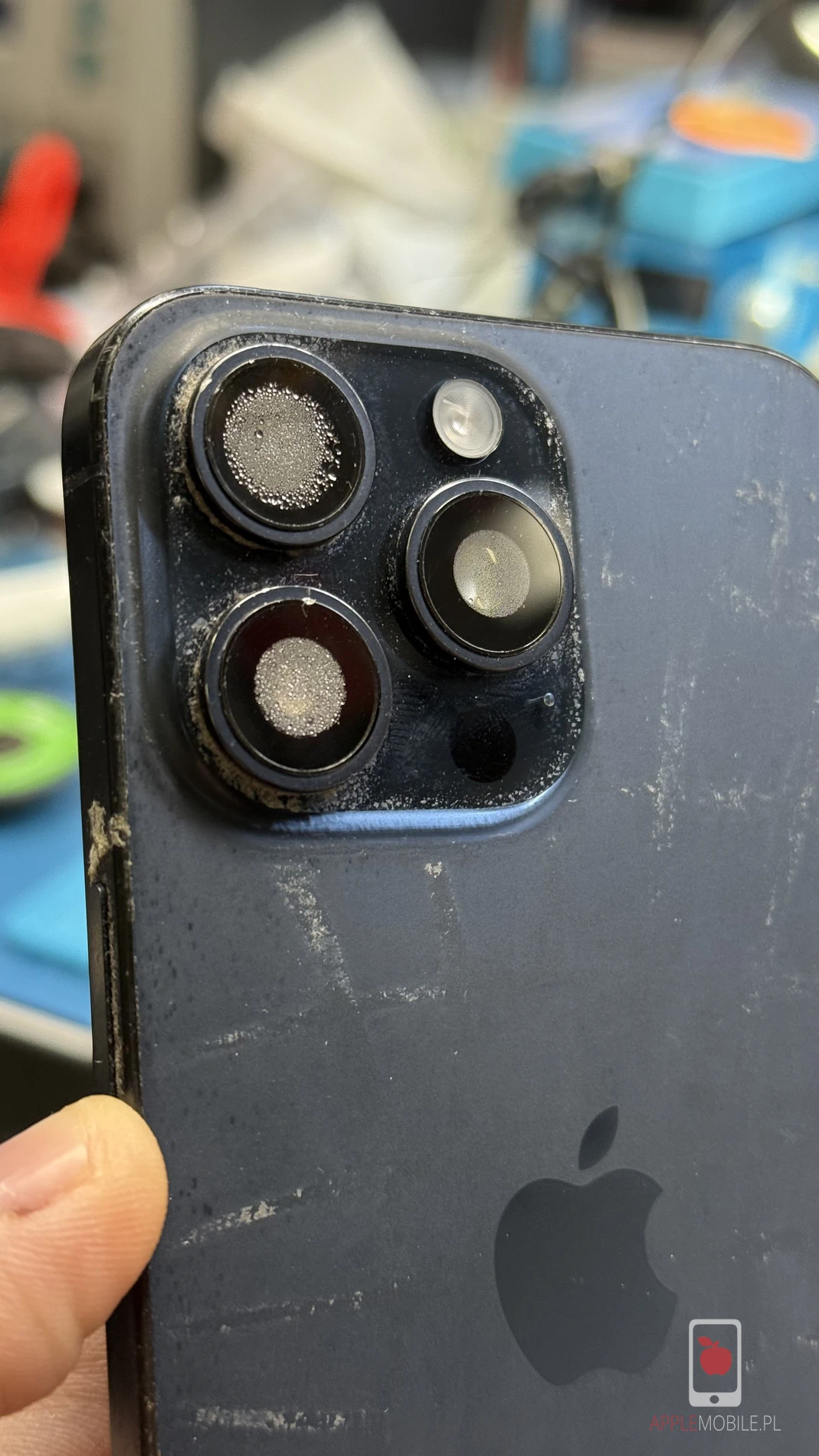 Zaparowane obiektywy w zamkniętym telefonie iPhone 15 Pro Max sugerują ingerencję cieczy.