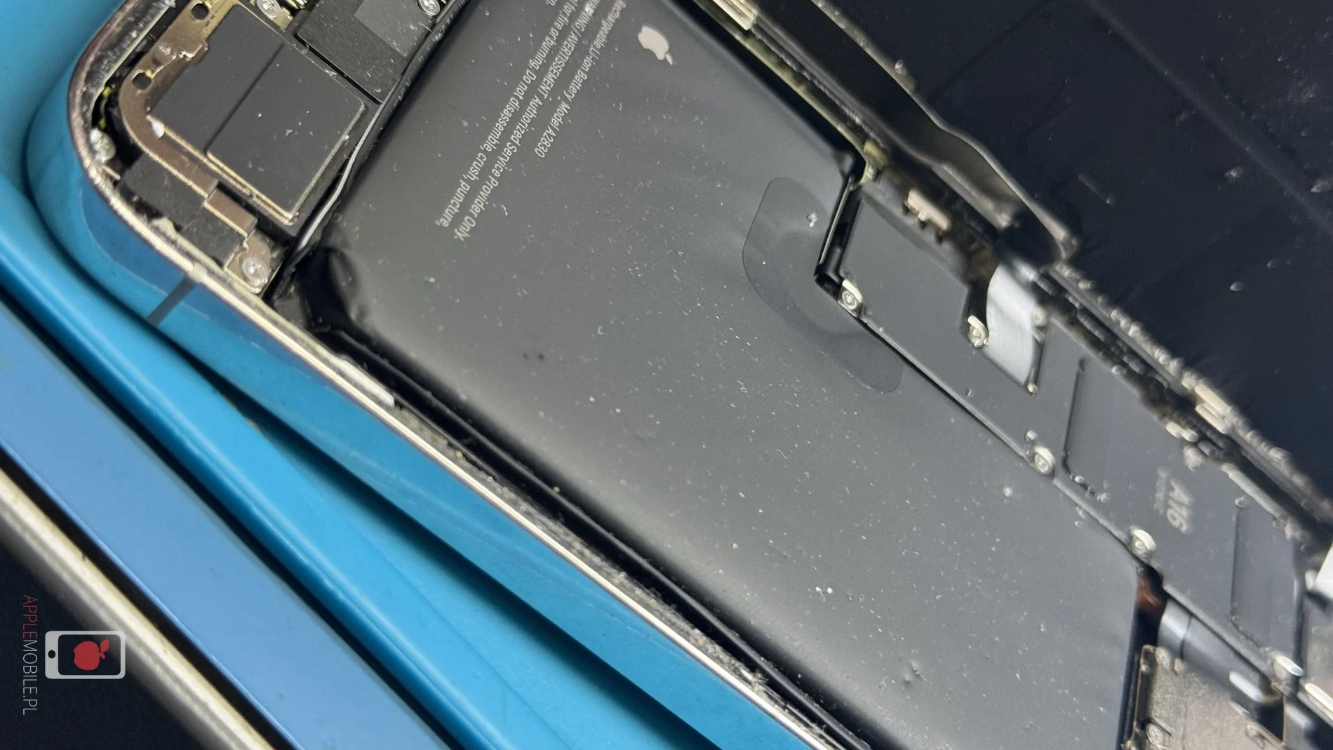 spuchnięta i podziurawiona bateria od drobinek szkła ze zbitej tylnej szybki obudowy w iPhone