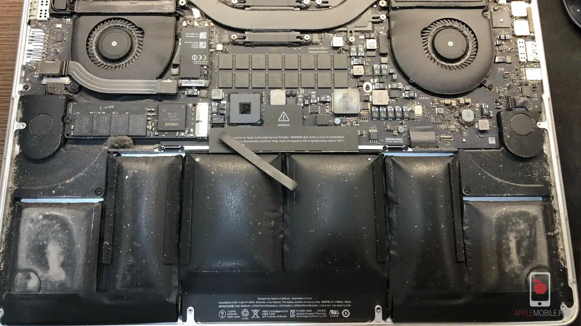 brudny i zakurzony macbook pro ze spuchniętą baterią