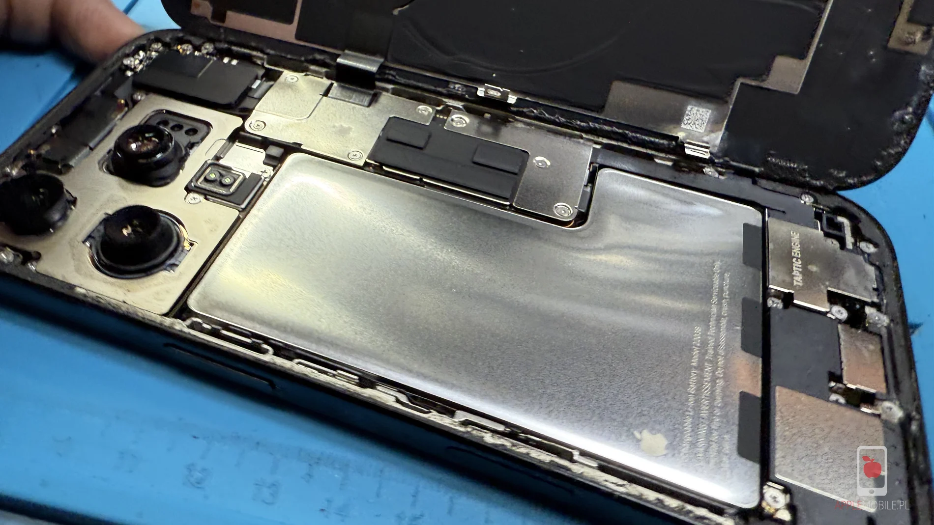 wnętrze telefonu iPhone 16 Pro z widoczną zużytą baterią