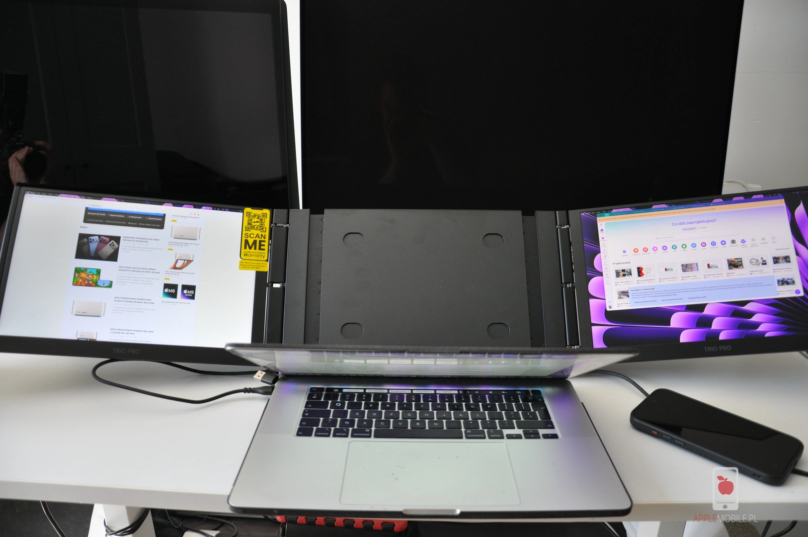 Za ekranem MacBooka na stojaku znajdują się przyciski do sterowania.